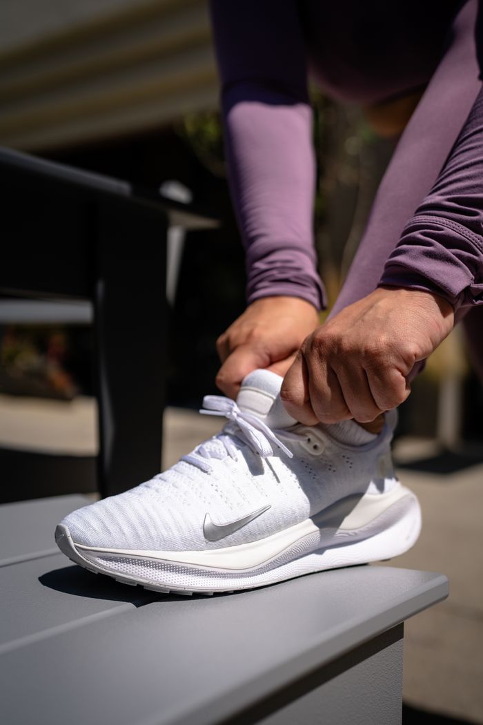Close-up of woman tying running shoes outdoors, perfect for athletic themes.